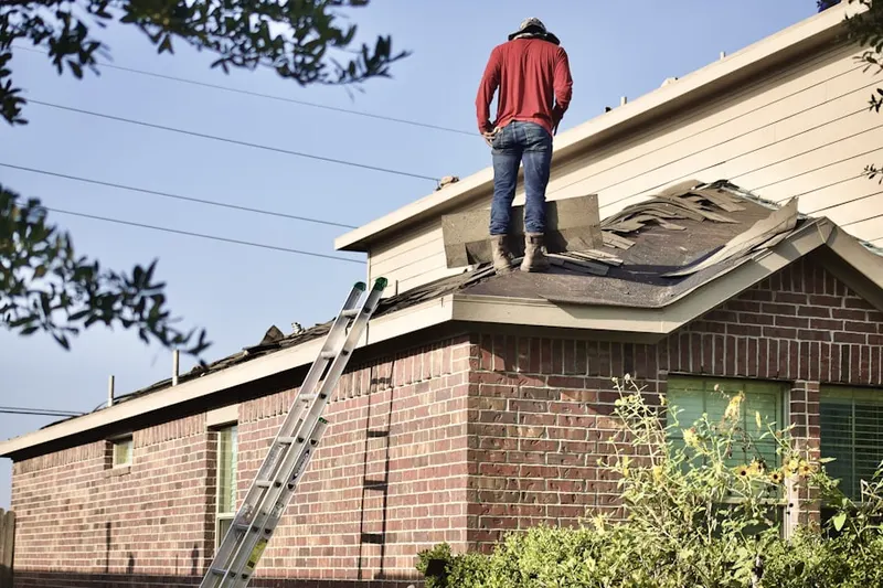 Professional roofer working on a residential roof in Mannhurst Oak Manors
